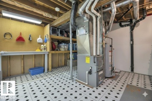 Unfinished below grade area featuring light floors, gas water heater, and heating unit - 4406 39 Ave, Leduc, AB - Indoor Photo Showing Basement