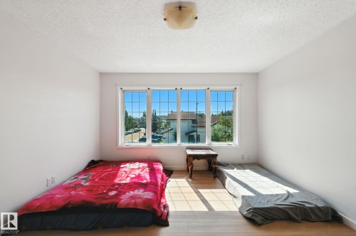 Bedroom featuring light wood-type flooring and a textured ceiling - 7836 7 Avenue, Edmonton, AB - Indoor Photo Showing Bedroom