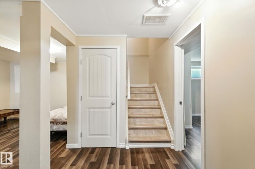 Staircase featuring wood finished floors and ornamental molding - 7836 7 Avenue, Edmonton, AB - Indoor Photo Showing Other Room