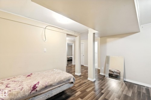 Bedroom with dark wood-type flooring and baseboards - 7836 7 Avenue, Edmonton, AB - Indoor Photo Showing Bedroom