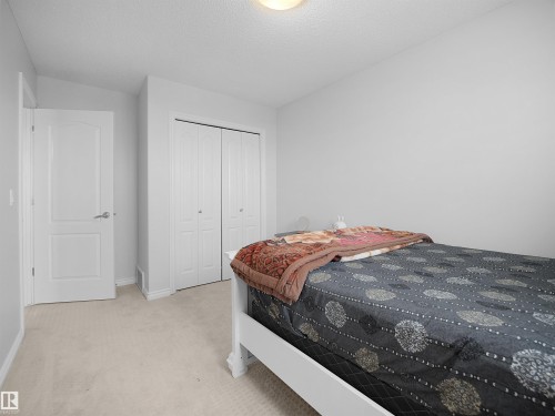 Bedroom with light colored carpet, a closet, and a textured ceiling - 1716 64 Street, Edmonton, AB - Indoor Photo Showing Bedroom