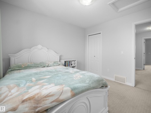 Bedroom with light carpet, a textured ceiling, and a closet - 1716 64 Street, Edmonton, AB - Indoor Photo Showing Bedroom