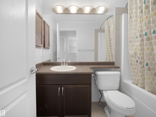 Full bath with vanity, shower / bath combination with curtain, and light tile patterned floors - 1716 64 Street, Edmonton, AB - Indoor Photo Showing Bathroom