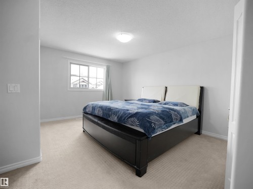 Bedroom with light colored carpet and a textured ceiling - 1716 64 Street, Edmonton, AB - Indoor Photo Showing Bedroom