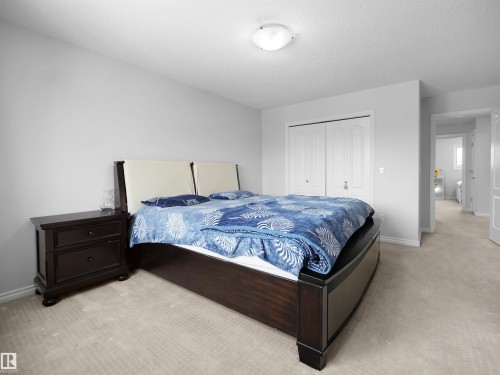 Bedroom featuring light colored carpet, a closet, and a textured ceiling - 1716 64 Street, Edmonton, AB - Indoor Photo Showing Bedroom