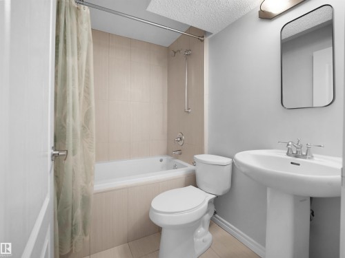 Basement Full bath with tiled shower / bath and a textured ceiling - 1716 64 Street, Edmonton, AB - Indoor Photo Showing Bathroom