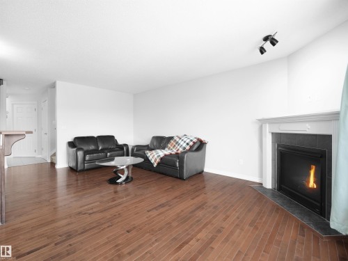 Living room with a tiled fireplace and dark wood finished floors - 1716 64 Street, Edmonton, AB - Indoor Photo Showing Living Room With Fireplace