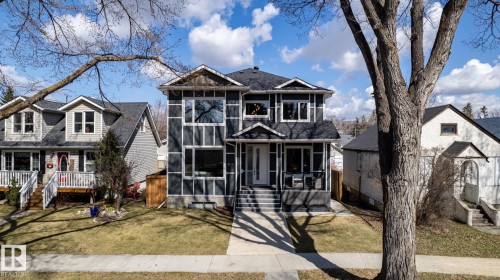 View of front facade with a sunroom, a front lawn, and roof with shingles - 10936 71 Avenue, Edmonton, AB - Outdoor With Facade