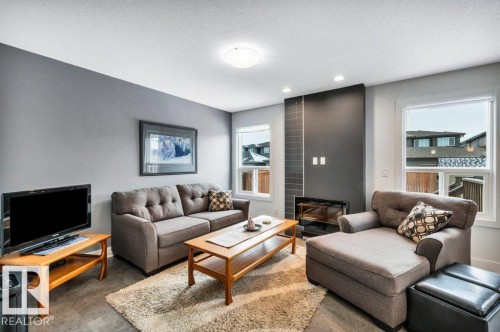 Living room with recessed lighting, a textured ceiling, and concrete flooring - 6485 King Wynd, Edmonton, AB - Indoor Photo Showing Living Room