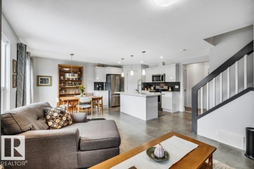Living room featuring finished concrete flooring and a textured ceiling - 6485 King Wynd, Edmonton, AB - Indoor Photo Showing Living Room