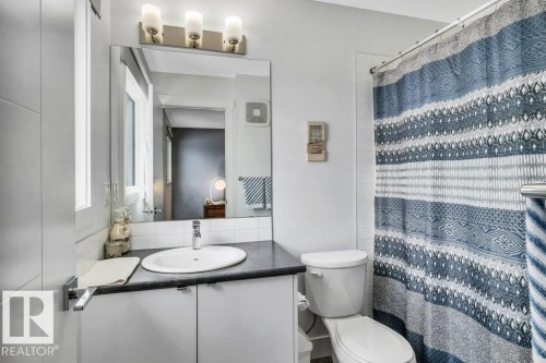 Bathroom with vanity, a shower with shower curtain, and decorative backsplash - 6485 King Wynd, Edmonton, AB - Indoor Photo Showing Bathroom