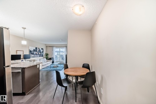 Dining room with dark wood-style flooring and a textured ceiling - 403 340 Windermere Road, Edmonton, AB - Indoor