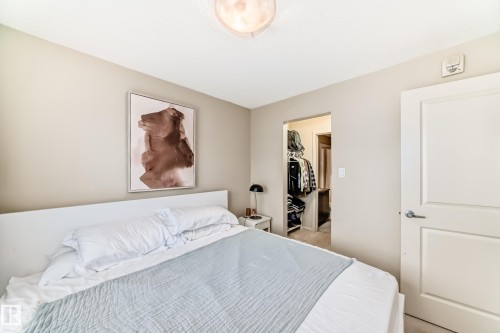 Bedroom with a spacious closet and light carpet - 403 340 Windermere Road, Edmonton, AB - Indoor Photo Showing Bedroom