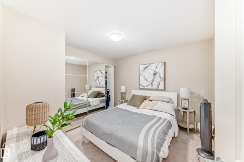 Bedroom with a closet, carpet flooring, and a textured ceiling - 403 340 Windermere Road, Edmonton, AB - Indoor Photo Showing Bedroom