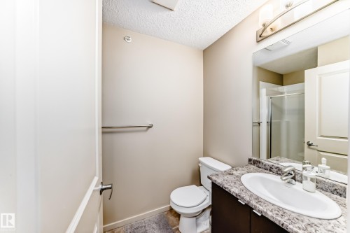 Bathroom with a stall shower, vanity, and a textured ceiling - 403 340 Windermere Road, Edmonton, AB - Indoor Photo Showing Bathroom