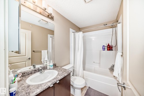 Bathroom featuring vanity, shower / tub combo, and a textured ceiling - 403 340 Windermere Road, Edmonton, AB - Indoor Photo Showing Bathroom