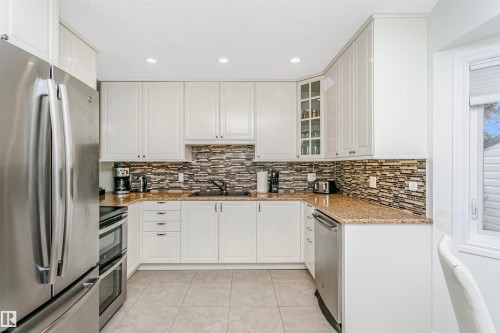 Kitchen featuring stainless steel appliances, light stone counters, recessed lighting, and white cabinets - 18507 92 Avenue, Edmonton, AB - Indoor Photo Showing Kitchen With Stainless Steel Kitchen With Upgraded Kitchen