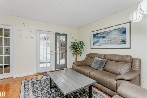 Living room featuring light wood-style flooring, a textured ceiling, and french doors - 18507 92 Avenue, Edmonton, AB - Indoor Photo Showing Living Room