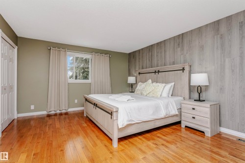 Bedroom featuring light wood-style floors, a closet, and an accent wall - 18507 92 Avenue, Edmonton, AB - Indoor Photo Showing Bedroom
