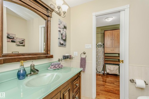 Bathroom featuring wainscoting, vanity, tile walls, light wood-type flooring, and a textured ceiling - 18507 92 Avenue, Edmonton, AB - Indoor Photo Showing Bathroom