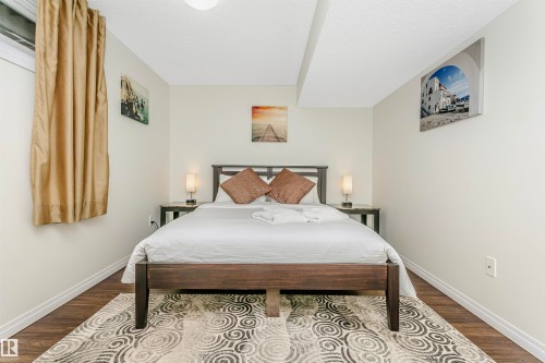 Bedroom featuring dark wood-type flooring and a textured ceiling - 18507 92 Avenue, Edmonton, AB - Indoor Photo Showing Bedroom