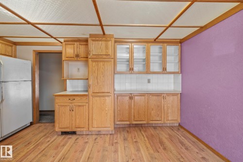 Kitchen with tasteful backsplash, freestanding refrigerator, light wood-type flooring, and glass insert cabinets - 10971 157 Street, Edmonton, AB - Indoor Photo Showing Kitchen