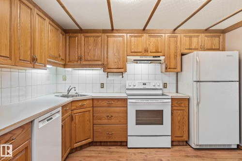 Kitchen with white appliances, light countertops, wood finish cabinets, and decorative backsplash - 10971 157 Street, Edmonton, AB - Indoor Photo Showing Kitchen