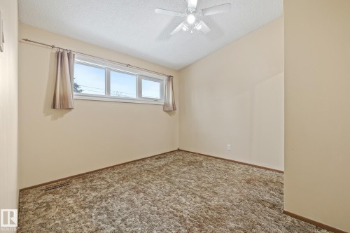 Carpeted primary bedroom with a textured ceiling and ceiling fan - 10971 157 Street, Edmonton, AB - Indoor Photo Showing Other Room