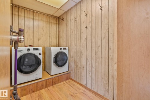 Laundry area with separate washer and dryer, a paneled ceiling, wooden walls, and light wood finished floors - 10971 157 Street, Edmonton, AB - Indoor Photo Showing Laundry Room