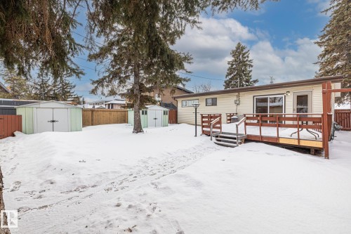 Snow covered house featuring a storage unit, a fenced backyard, and a deck - 10971 157 Street, Edmonton, AB - Outdoor