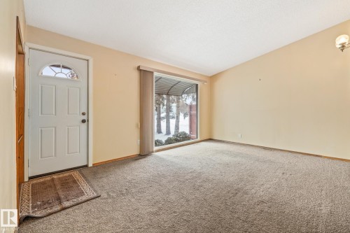 Foyer entrance with light colored carpet and a textured ceiling - 10971 157 Street, Edmonton, AB - Indoor Photo Showing Other Room