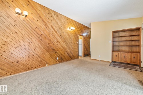 Carpeted living room featuring wood walls and an accent wall - 10971 157 Street, Edmonton, AB - Indoor Photo Showing Other Room