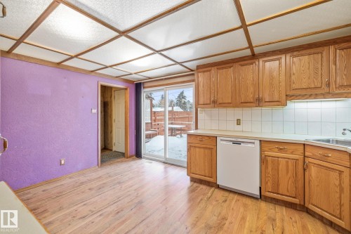 Dining area wood finish cabinets, light wood finished floors, and white dishwasher - 10971 157 Street, Edmonton, AB - Indoor Photo Showing Kitchen