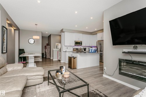 Living area with light wood finished floors, recessed lighting, and a textured ceiling - 7322 Chivers Crescent, Edmonton, AB - Indoor Photo Showing Living Room