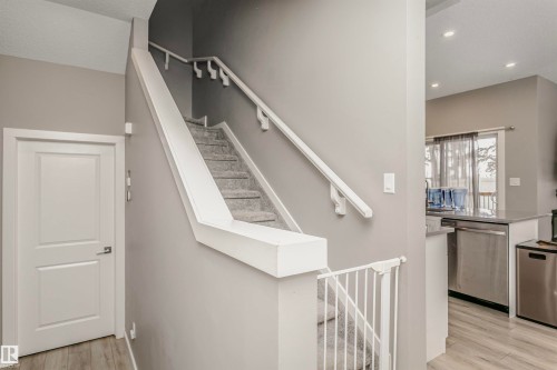 Stairs with wood finished floors and recessed lighting - 7322 Chivers Crescent, Edmonton, AB - Indoor Photo Showing Other Room