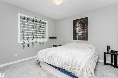 Carpeted bedroom featuring baseboards and a textured ceiling - 7322 Chivers Crescent, Edmonton, AB - Indoor Photo Showing Bedroom