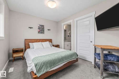 Primary Bedroom featuring ensuite bathroom, carpet, and a textured ceiling - 1315 Chappelle Boulevard, Edmonton, AB - Indoor Photo Showing Bedroom