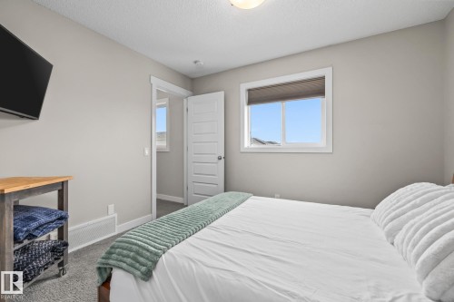 Primary Bedroom featuring dark carpet and a textured ceiling - 1315 Chappelle Boulevard, Edmonton, AB - Indoor Photo Showing Bedroom