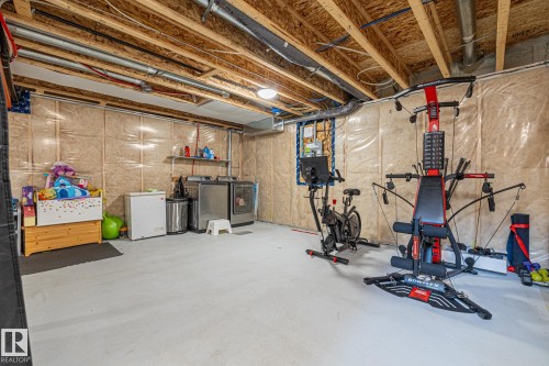 Laundry area and workout area with concrete floors and washing machine and clothes dryer - 1315 Chappelle Boulevard, Edmonton, AB - Indoor Photo Showing Basement