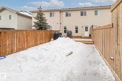 Snow covered rear of property featuring a fenced backyard and a wooden deck - 1315 Chappelle Boulevard, Edmonton, AB - Outdoor With Exterior