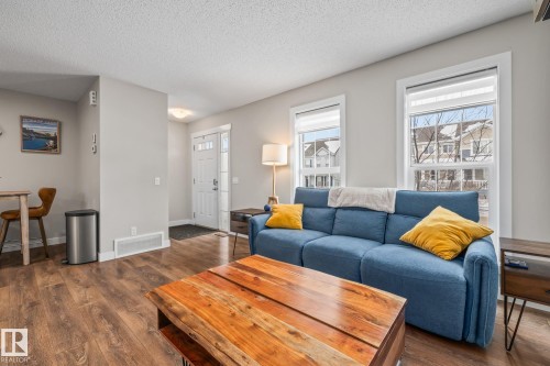 Living room featuring dark wood finished floors and a textured ceiling - 1315 Chappelle Boulevard, Edmonton, AB - Indoor Photo Showing Living Room