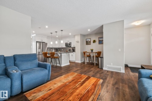 Living room with dark wood-style flooring, recessed lighting, and a textured ceiling - 1315 Chappelle Boulevard, Edmonton, AB - Indoor Photo Showing Living Room