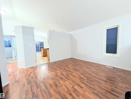 Empty room featuring vaulted ceiling and dark wood finished floors - 3307 24 Avenue, Edmonton, AB - Indoor Photo Showing Other Room