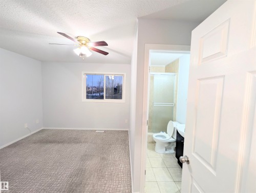Full bath featuring a stall shower, a ceiling fan, a textured ceiling, and light tile patterned floors - 3307 24 Avenue, Edmonton, AB - Indoor