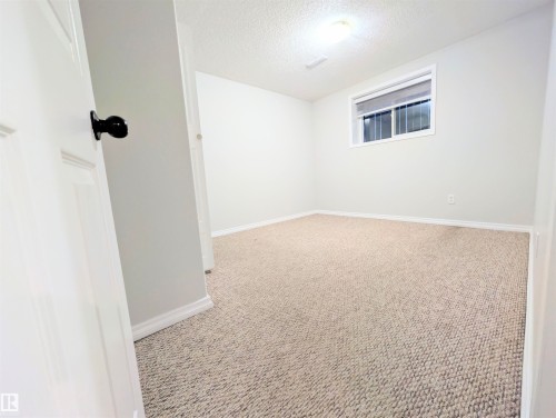 Empty room featuring a textured ceiling and light carpet - 3307 24 Avenue, Edmonton, AB - Indoor Photo Showing Other Room