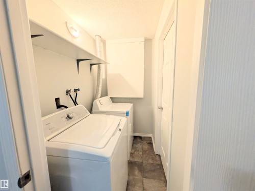 Laundry area with a textured ceiling and separate washer and dryer - 3307 24 Avenue, Edmonton, AB - Indoor Photo Showing Laundry Room