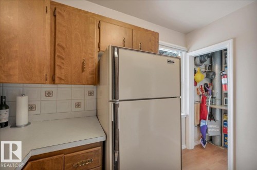 Kitchen with freestanding refrigerator, light countertops, wood finish cabinetry, and backsplash - 7934 81 Avenue Nw, Edmonton, AB - Indoor