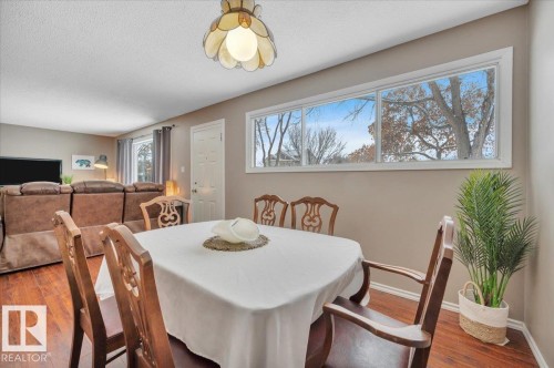 Dining room featuring wood finished floors and a textured ceiling - 7934 81 Avenue Nw, Edmonton, AB - Indoor Photo Showing Dining Room