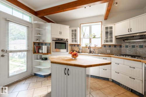 Kitchen featuring open shelves, white cabinetry, stainless steel oven, decorative backsplash, and glass insert cabinets - 11415 85 Street, Edmonton, AB - Indoor Photo Showing Kitchen