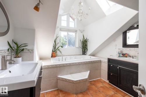 Bathroom with two vanities, a skylight, a garden tub, light tile patterned flooring, and vaulted ceiling - 11415 85 Street, Edmonton, AB - Indoor Photo Showing Bathroom